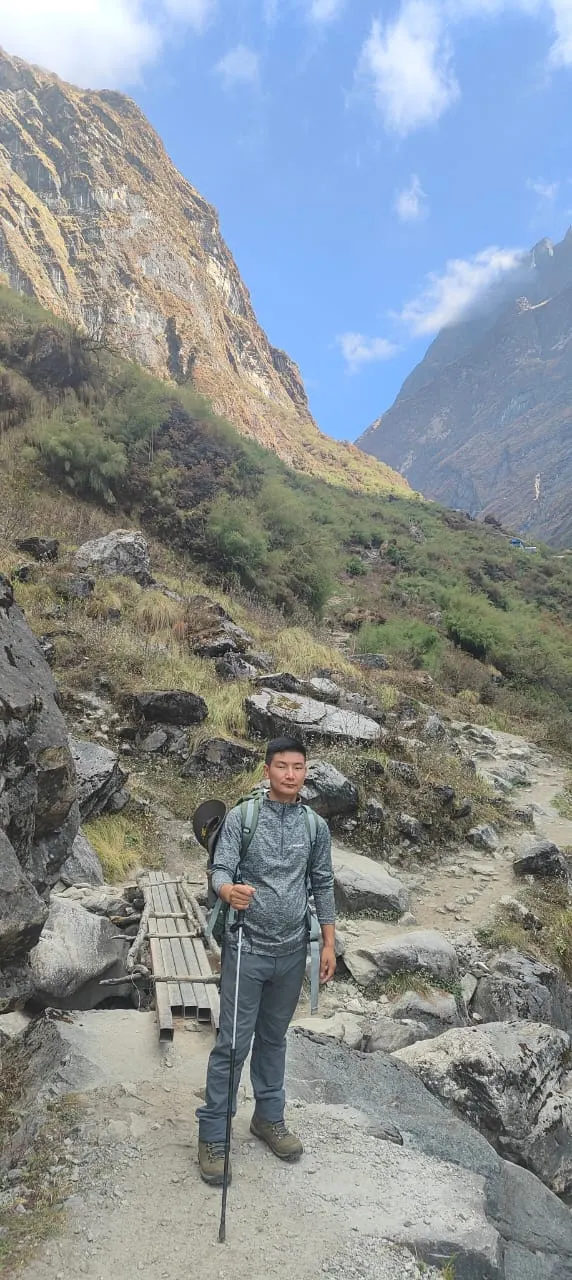 A trekker on a rocky trail in a deep, steep-sided valley
